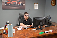 Shop Manager (Justin Patterson) in his office