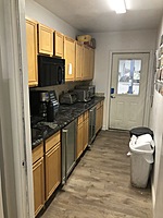 Kitchen area with 3 refrigerators, sink, microwave and toaster ovens